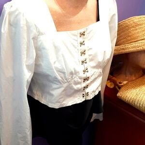 Cute long sleeve cotton poly blend crop top with hook and eye closures.